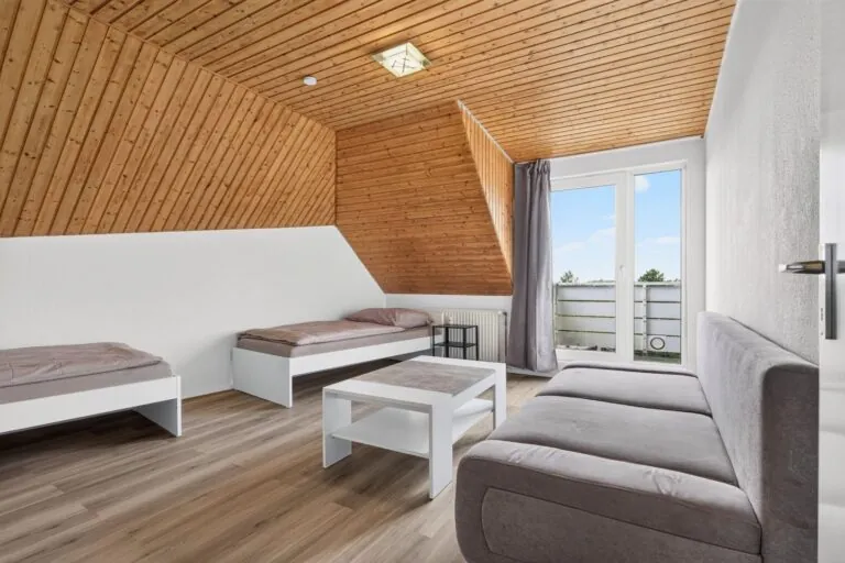Wohnbereich mit Sofa im Dachgeschoss-Apartment – Boardinghouse Solingen