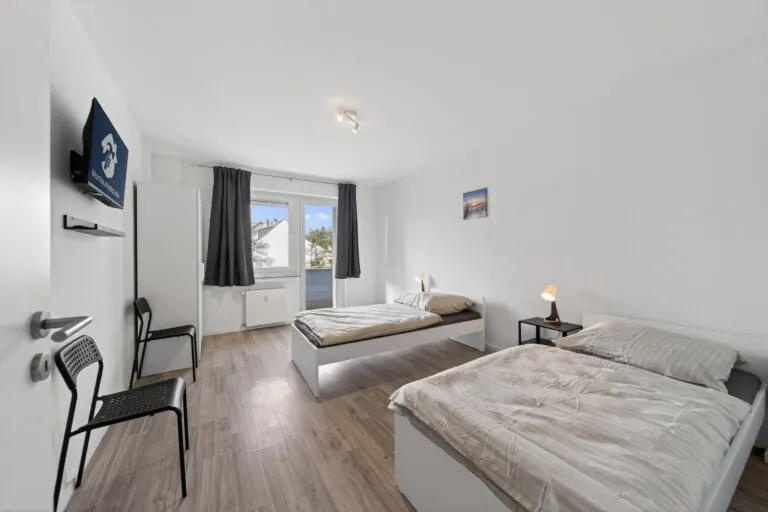 Schlafzimmer mit zwei Einzelbetten und Schreibtisch – Monteurwohnung Solingen Birkenweiher