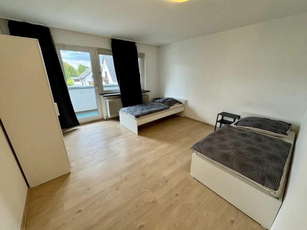 Schlafzimmer mit Balkonzugang in der Monteurwohnung Langenfeld